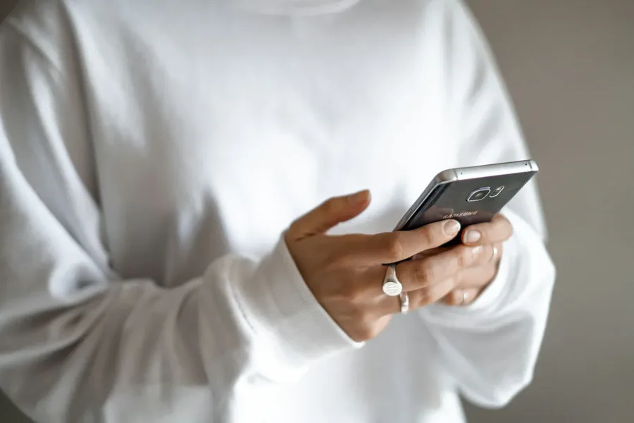 Person sending a text from a smartphone